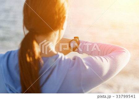 Runner woman with heart rate monitor running on beach 33799541