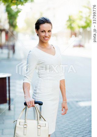 Business woman pulling suitcase bag walking in city 33799776