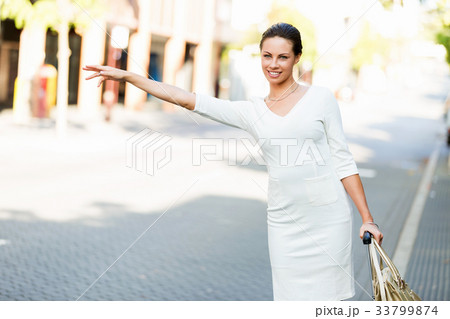 Business woman pulling suitcase bag walking in city Business woman pulling suitcase bag walking in city 33799874