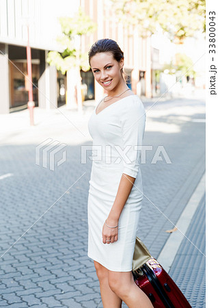 Business woman pulling suitcase bag walking in city Business woman pulling suitcase bag walking in city 33800043