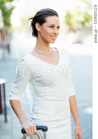 Business woman pulling suitcase bag walking in city 33800129