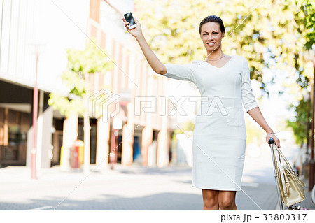 Business woman pulling suitcase bag walking in city 33800317
