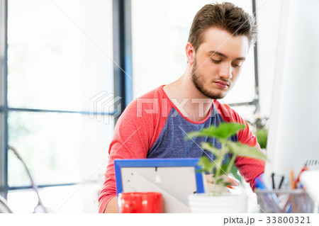 Young man working in office Young man working in office 33800321