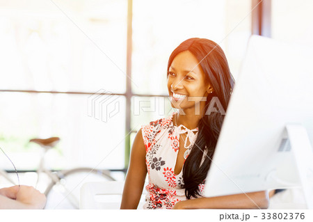 Portrait of smiling afro-american office worker sitting in offfice Portrait of smiling afro-american office worker sitting in offfice 33802376