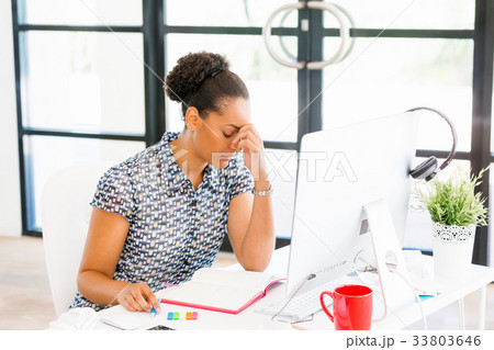 Portrait of tired afro-american office worker sitting in offfice Portrait of tired afro-american office worker sitting in offfice 33803646