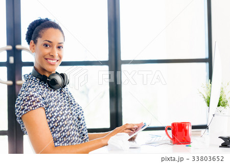 Portrait of smiling afro-american office worker sitting in offfice Portrait of smiling afro-american office worker sitting in offfice 33803652