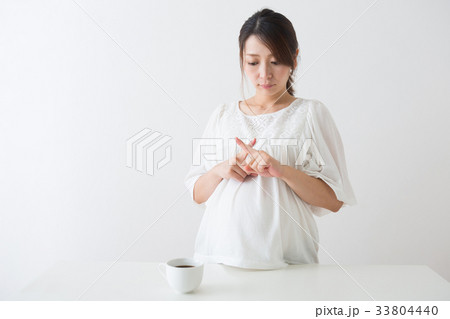 コーヒーを見る妊婦さん コーヒーを見る妊婦さん 33804440