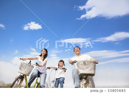 happy family riding bicycle with cloud background happy family riding bicycle with cloud background 33805683
