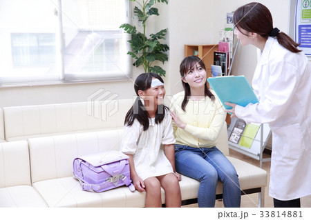 待合室で女医に声をかけられる女の子と母親 待合室で女医に声をかけられる女の子と母親 33814881