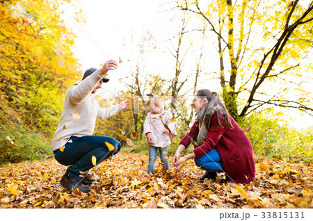 Beautiful young family on a walk in autumn forest. 33815131