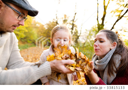 Beautiful young family on a walk in autumn forest. 33815133