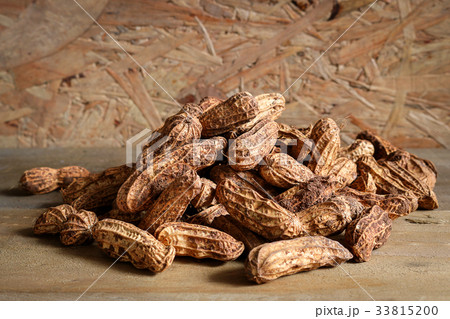 Pile raw peanuts in shell on wooden background Pile raw peanuts in shell on wooden background 33815200