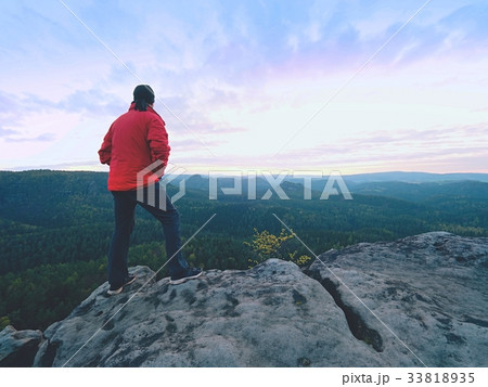 Hiker in red jacket climbed up to peak enjoy view 33818935