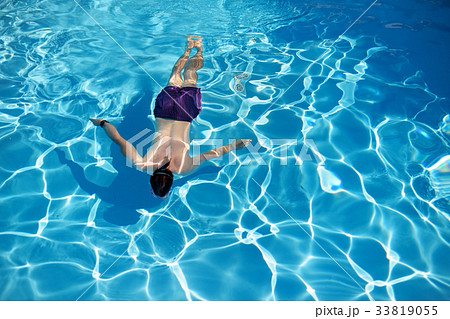Top view of a man swimming in a swimming pool on sunny summer day 33819055