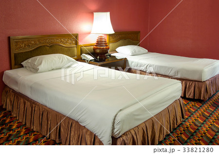 Double bed with table lamp in the bedroom 33821280