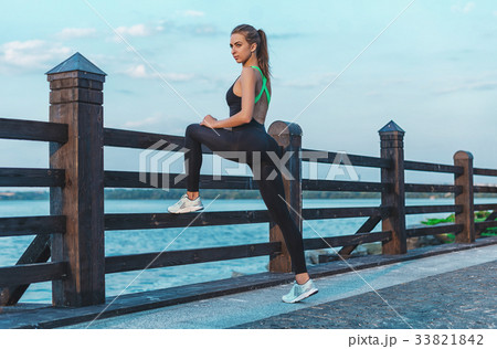 Woman stretching in sunset. doing yoga near lake Woman stretching in sunset. doing yoga near lake 33821842