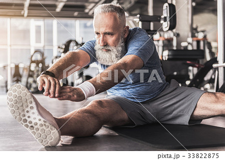 Serious old bearded man is enjoying exercises in 33822875