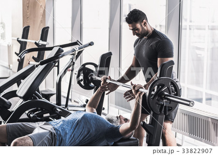 Senior male doing exercises with his trainer in 33822907