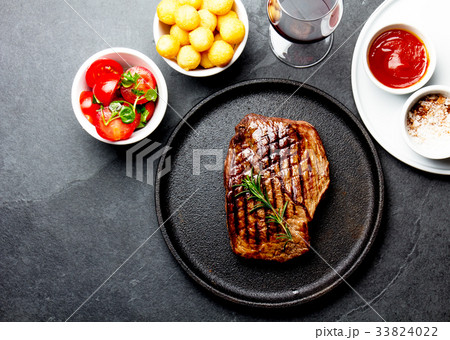 Grilled beef steak served on cast iron plate with 33824022