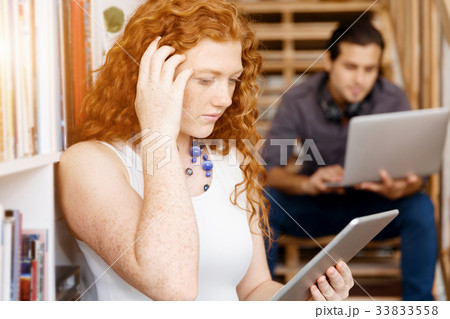 Portrait of two young people sitting at the stairs in office Portrait of two young people sitting at the stairs in office 33833558
