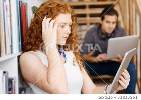 Portrait of two young people sitting at the stairs in office Portrait of two young people sitting at the stairs in office 33833561