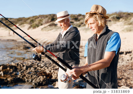 Senior man fishing with his grandson 33833869