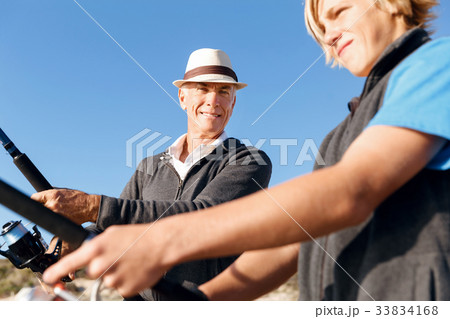 Senior man fishing with his grandson Senior man fishing with his grandson 33834168