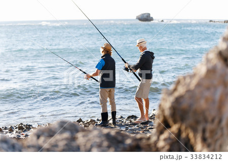 Senior man fishing with his grandson Senior man fishing with his grandson 33834212