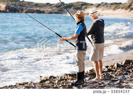 Senior man fishing with his grandson Senior man fishing with his grandson 33834237
