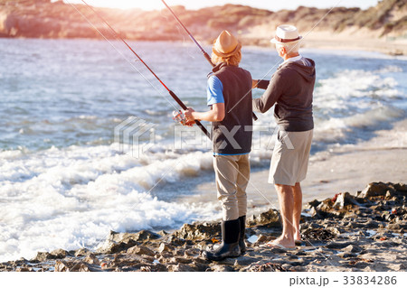 Senior man fishing with his grandson 33834286