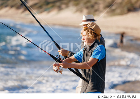 Teenage boy fishing at sea Teenage boy fishing at sea 33834692