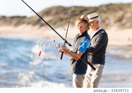 Senior man fishing with his grandson 33834711