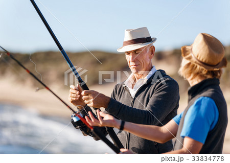 Senior man fishing with his grandson 33834778
