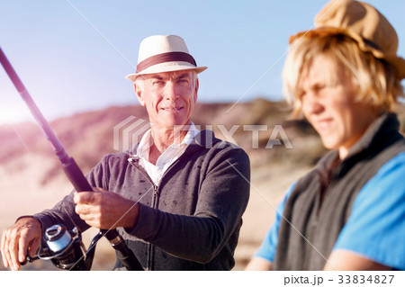 Senior man fishing with his grandson Senior man fishing with his grandson 33834827