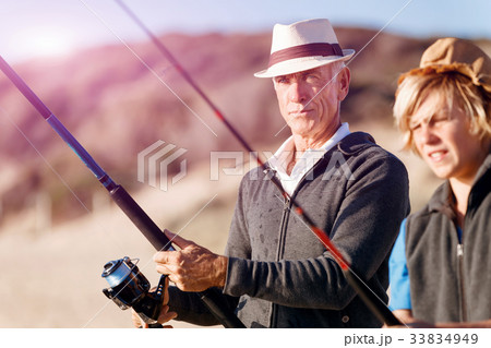 Senior man fishing with his grandson 33834949