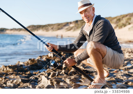 Senior man fishing at sea side Senior man fishing at sea side 33834986