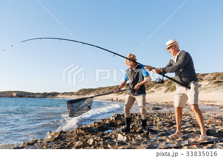 Senior man fishing with his grandson 33835016