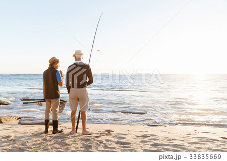 Senior man fishing with his grandson Senior man fishing with his grandson 33835669