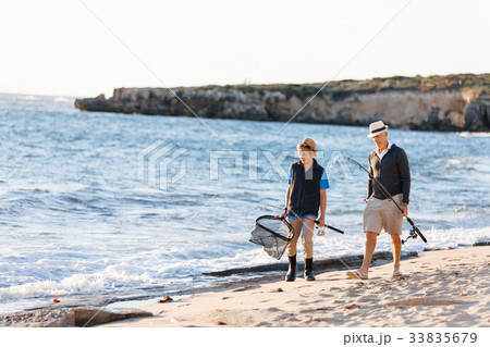 Senior man fishing with his grandson 33835679