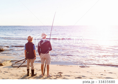 Senior man fishing with his grandson Senior man fishing with his grandson 33835680