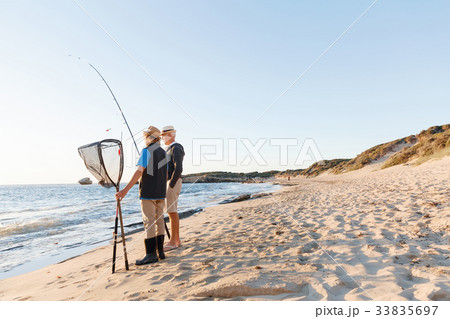 Senior man fishing with his grandson Senior man fishing with his grandson 33835697