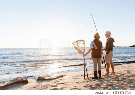 Senior man fishing with his grandson Senior man fishing with his grandson 33835716