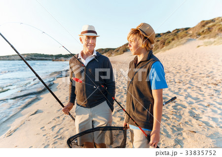 Senior man fishing with his grandson Senior man fishing with his grandson 33835752