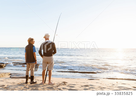 Senior man fishing with his grandson Senior man fishing with his grandson 33835825