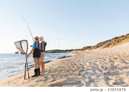 Senior man fishing with his grandson 33835876