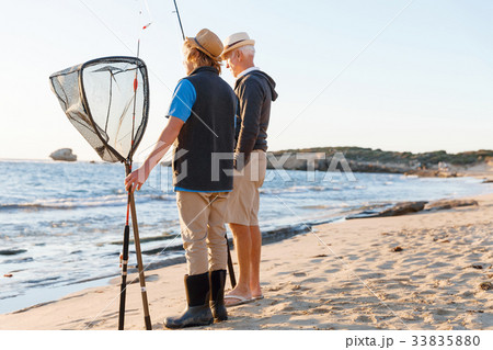 Senior man fishing with his grandson Senior man fishing with his grandson 33835880