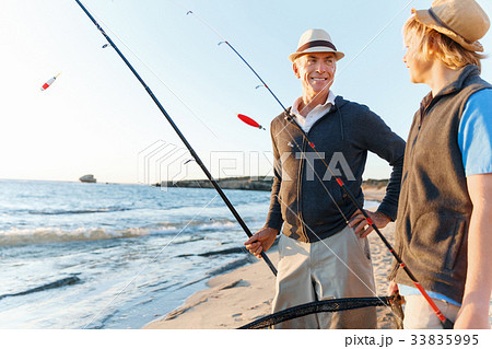 Senior man fishing with his grandson Senior man fishing with his grandson 33835995