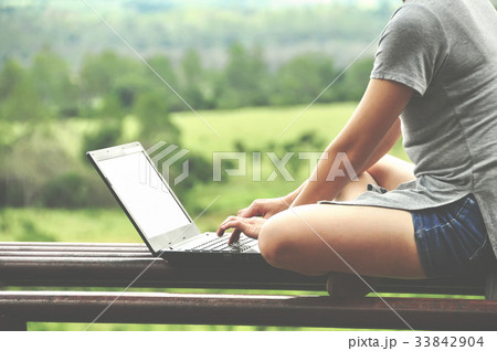 young woman using a computer at park 33842904