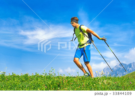 Young man practicing nordic walking in nature Young man practicing nordic walking in nature 33844109