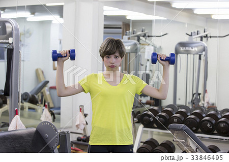 大阪市内のトレーニングジムで肩の運動をしているハーフの若い女性 33846495